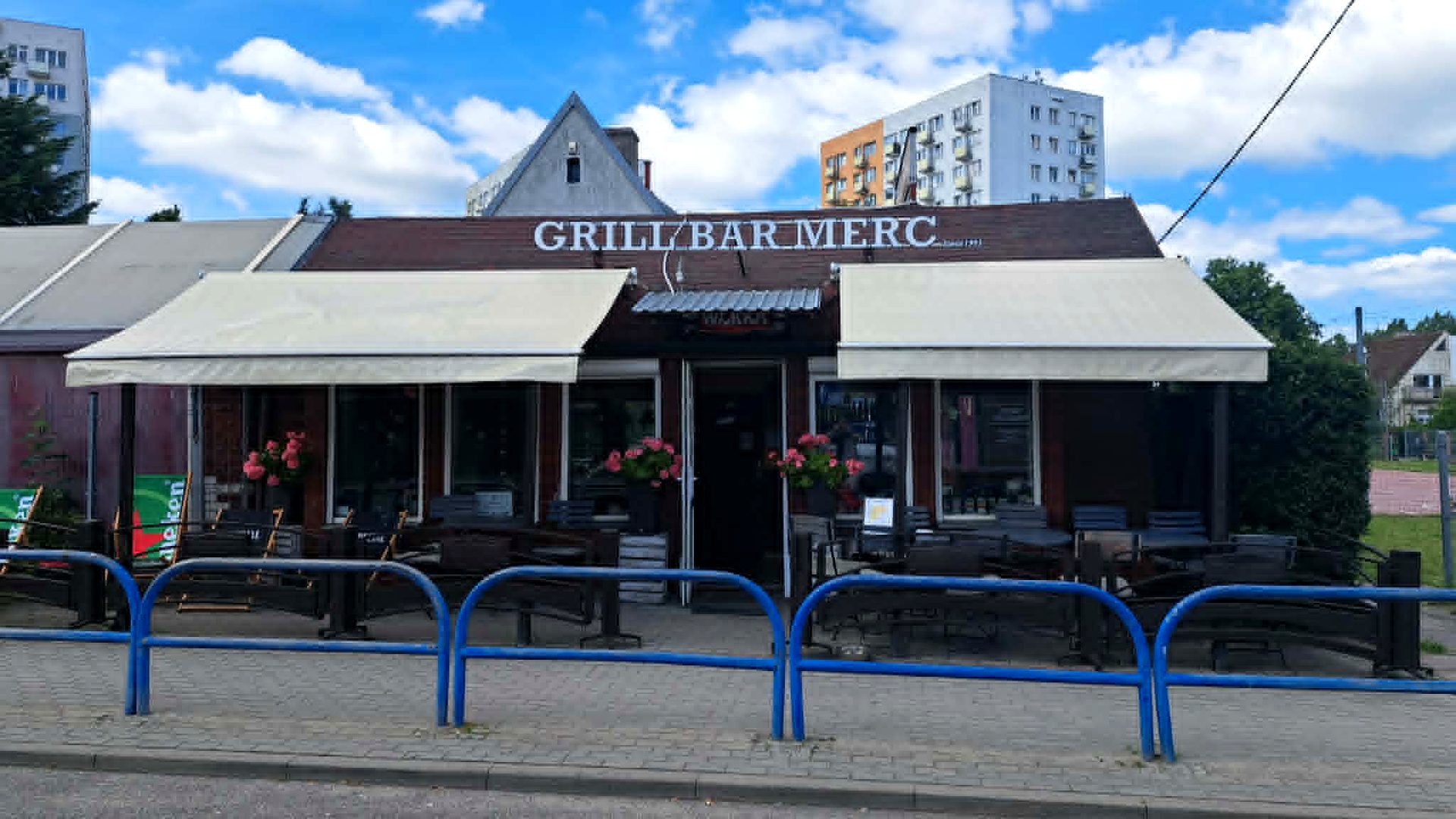 Budynek Grill Bar Merc przy ul. Bitwy Oliwskiej 20 w Gdańsku z markizami i ogródkiem